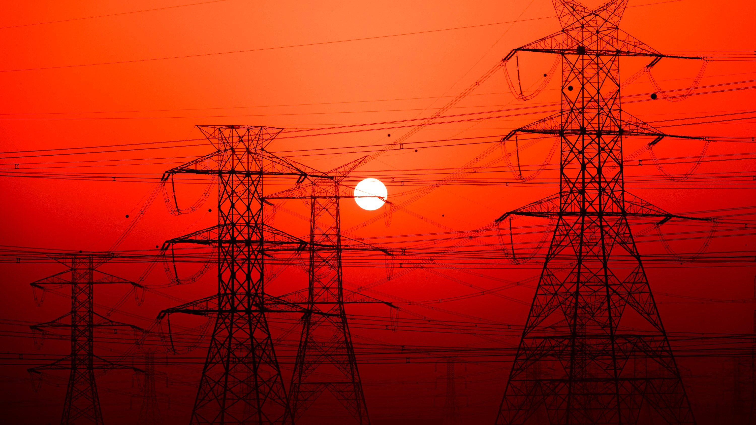 Powerlines set against a red sky