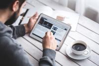 Image: man on tablet with a cup of coffee. Title: FAQs about Shareholder Activism