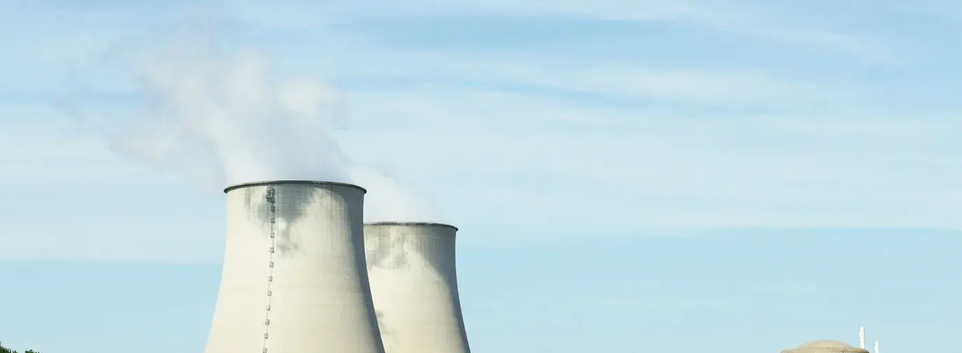 Image: nuclear energy plant smokestacks emitting pollution.